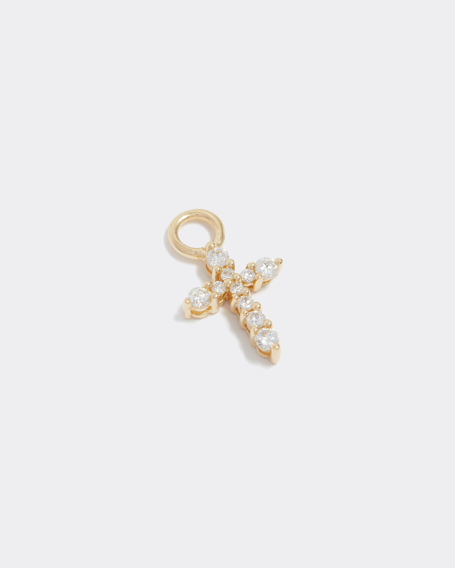 small cross charm made of gold and diamonds, to be worn on an earring or necklace, product shot