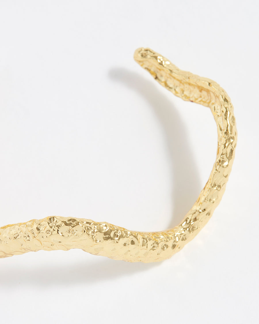 close up of textured curved gold bracelet cuff