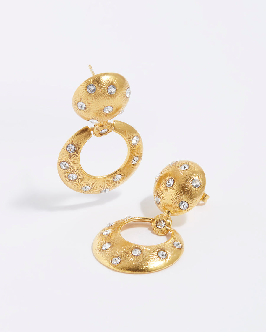 product shot of chunky gold door knocker style earrings with clear crystal stars etched into the gold plated silver