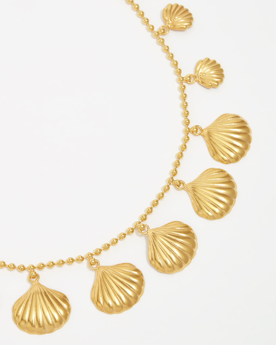 product shot of yellow gold plated necklace with shells attached around the necklace close up