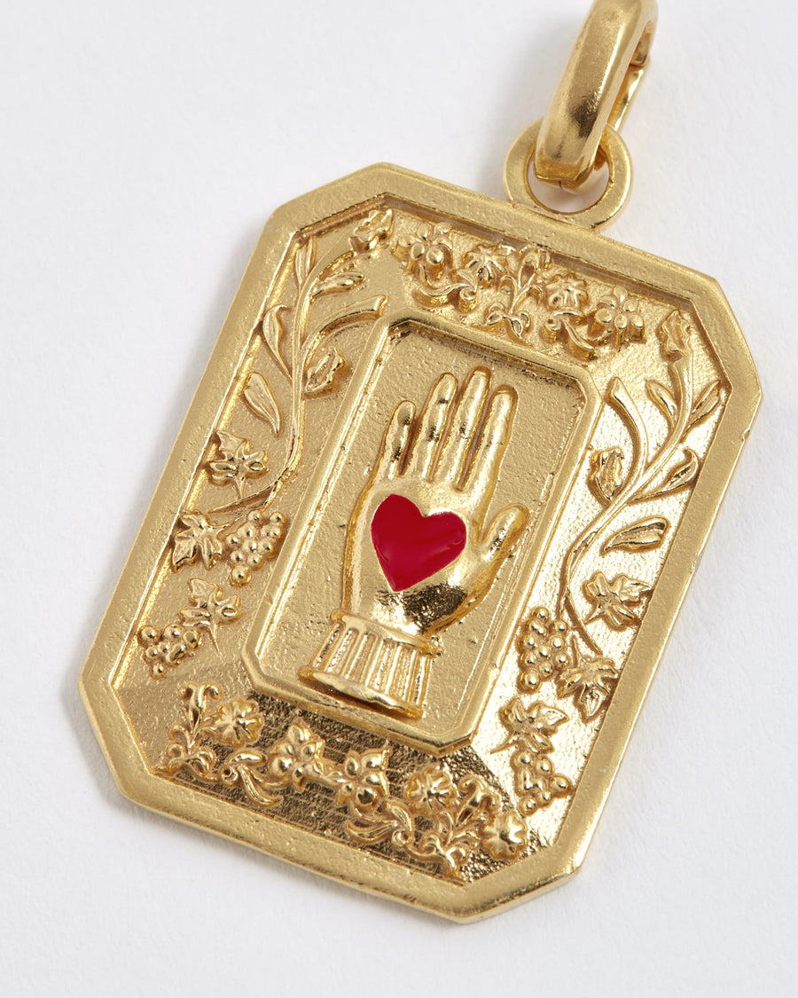Soru Jewellery gold vintage style charm showing a red enamel heart in hand
