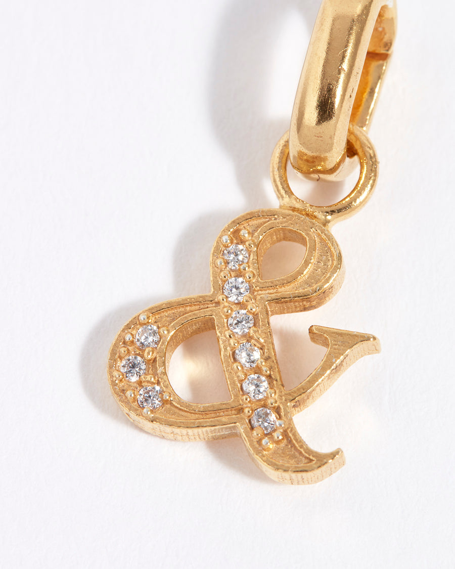 close up of gold and crystal ampersand charm 