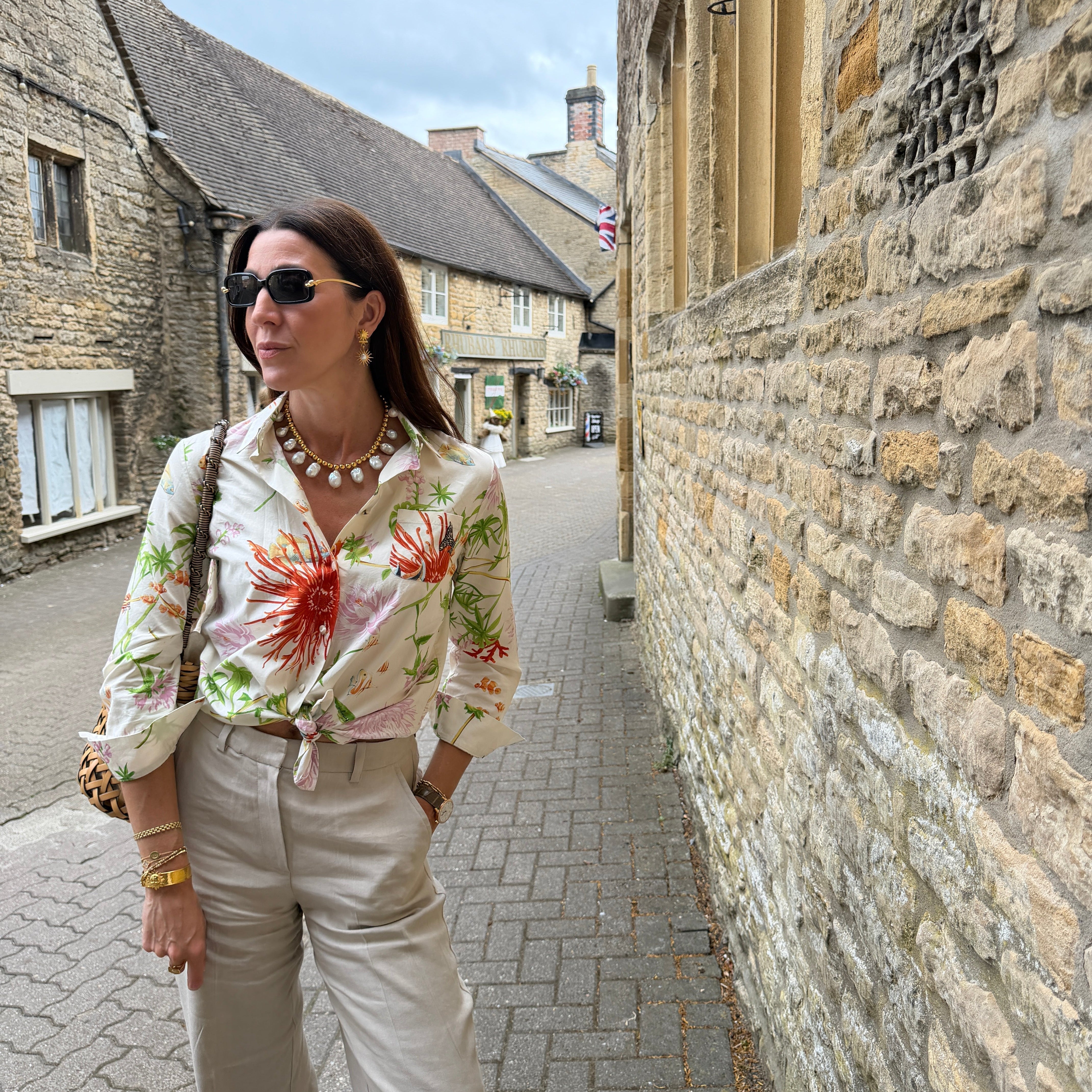 marianna stood on a Catswold street wearing a colourful short and beige trousers 