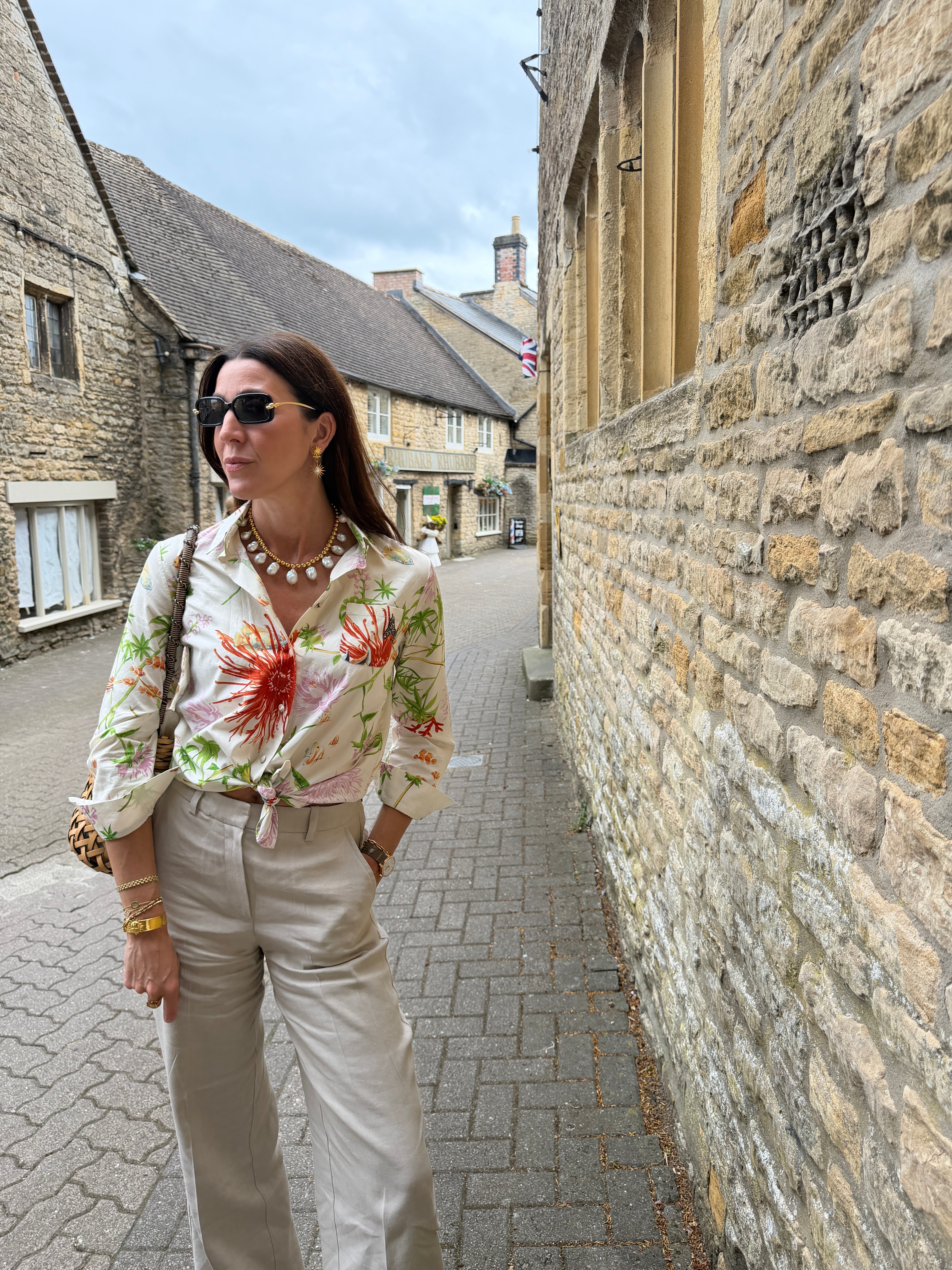 marianna stood on a Catswold street wearing a colourful short and beige trousers 