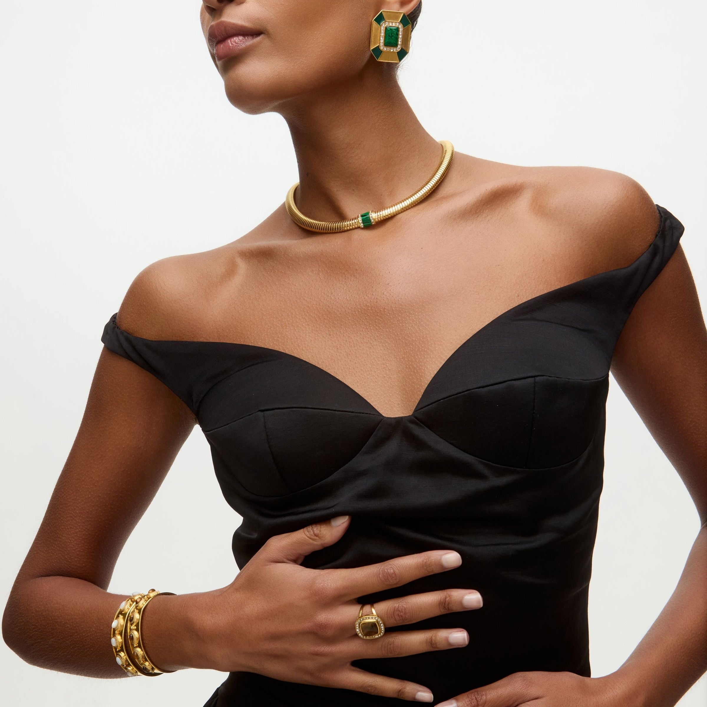 photo of model wearing black dress with greeh and gold malachite earrings and necklace