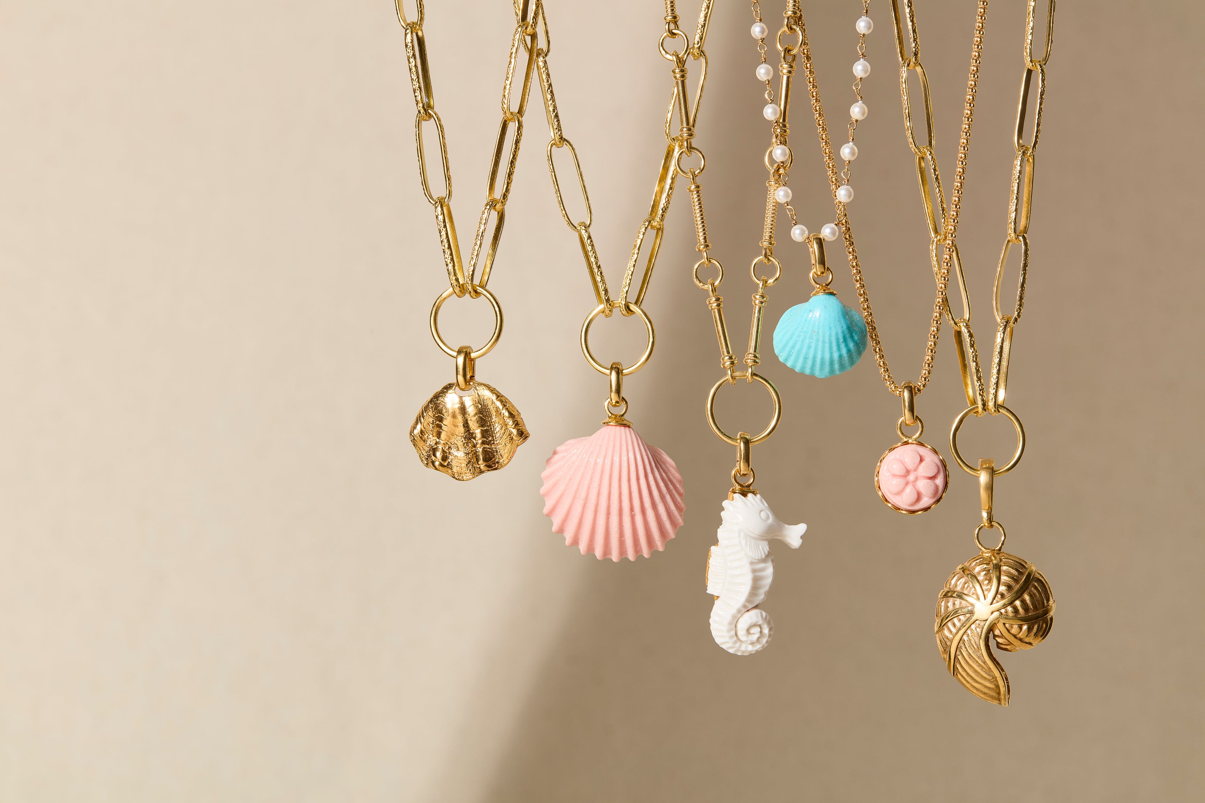 image of 6 charm necklaces with pink and turquoise shells, gold shells and a white seahorse