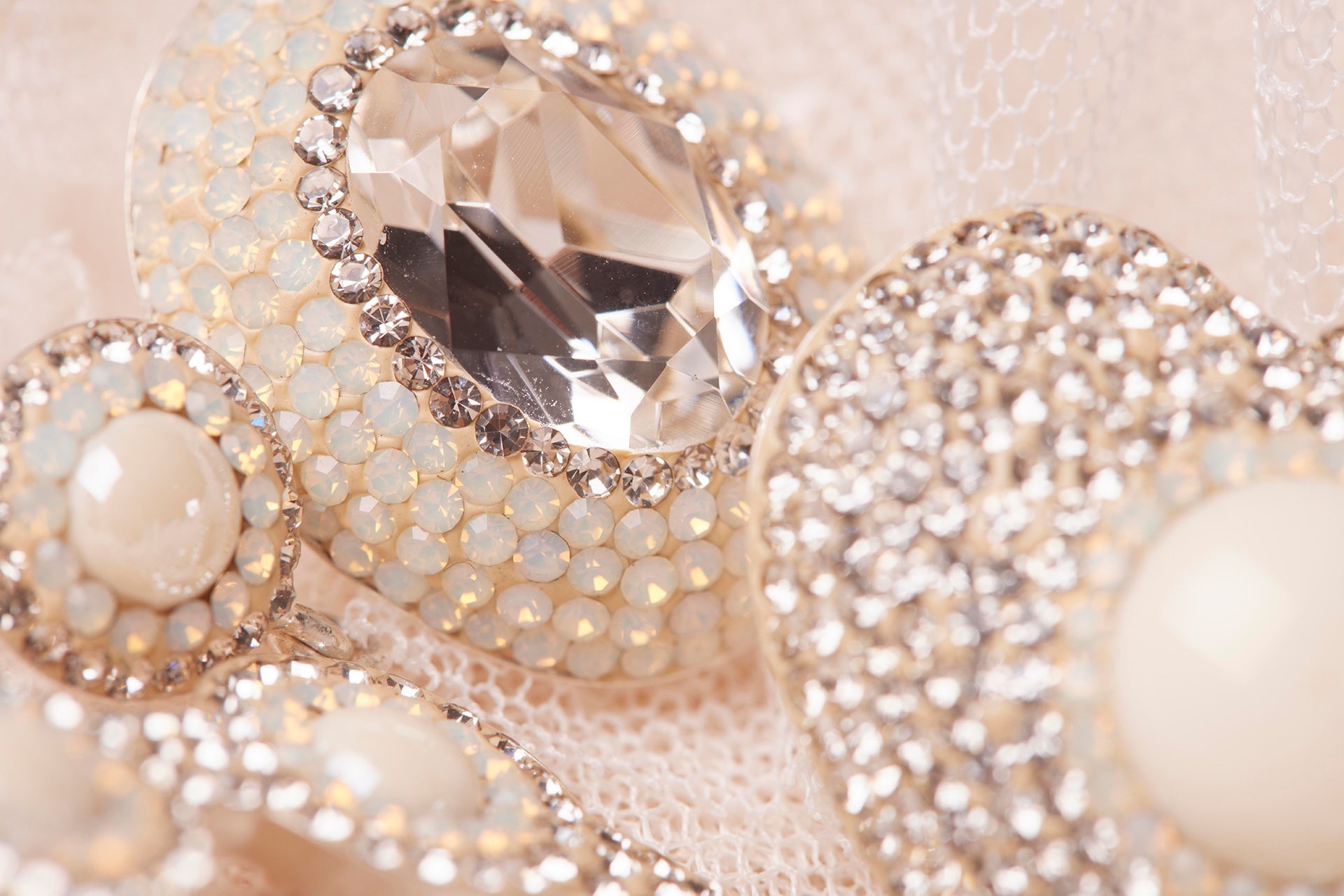 Blonde haired lady wearing a tulle embellished dress with matching sparkly pearl hoop earrings with diamond detailing.