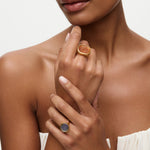 Woman wearing two rings on her fingers against a neutral background