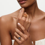 Woman wearing two rings on her fingers against a neutral background
