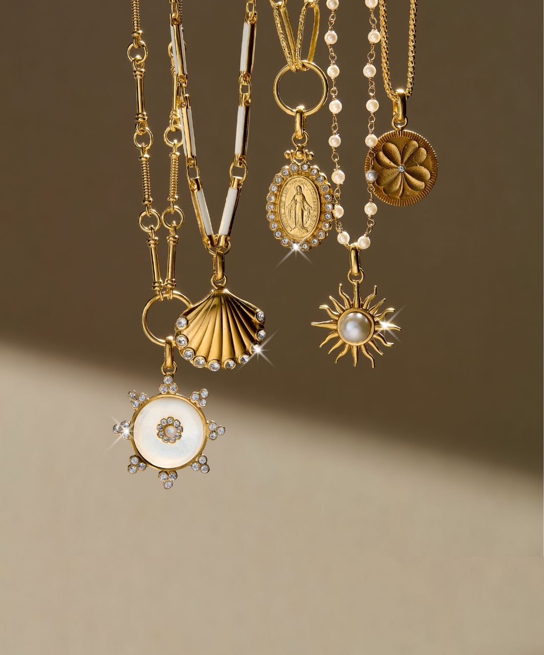 Group image of charm and pendant necklace on a beige background