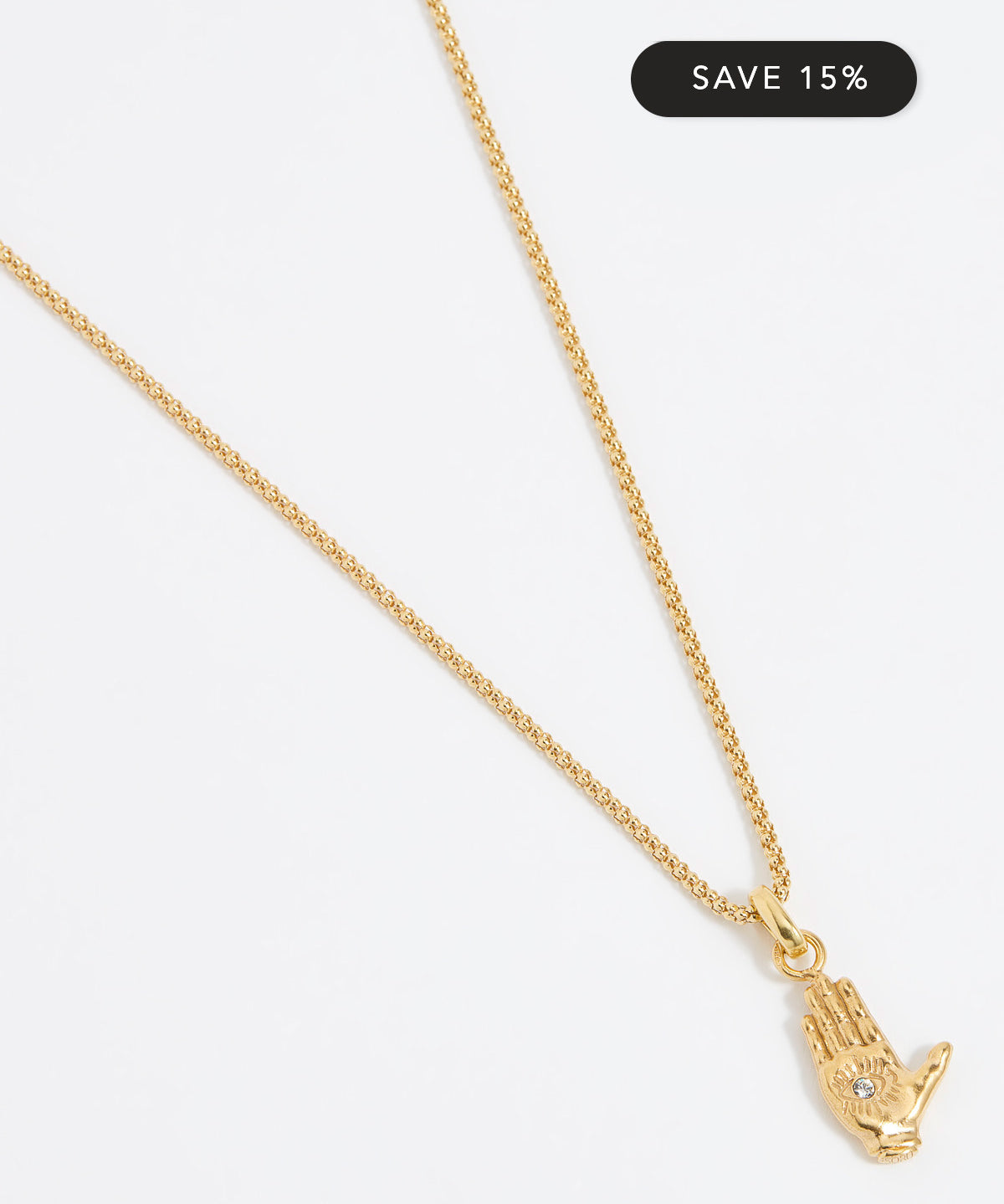 Close up shot of a gold hand-shaped charm featuring an inset eye symbol in the palm, set with a clear crystal hung from a Soru rope chain on a white background.