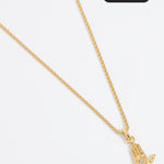 Close up shot of a gold hand-shaped charm featuring an inset eye symbol in the palm, set with a clear crystal hung from a Soru rope chain on a white background.