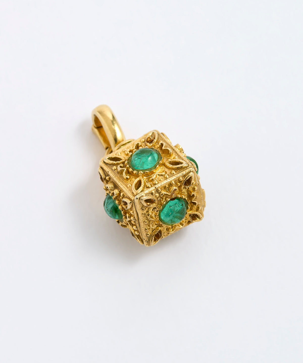 A gold cube charm featuring green emerald-cut gemstones on each side, on a white background.