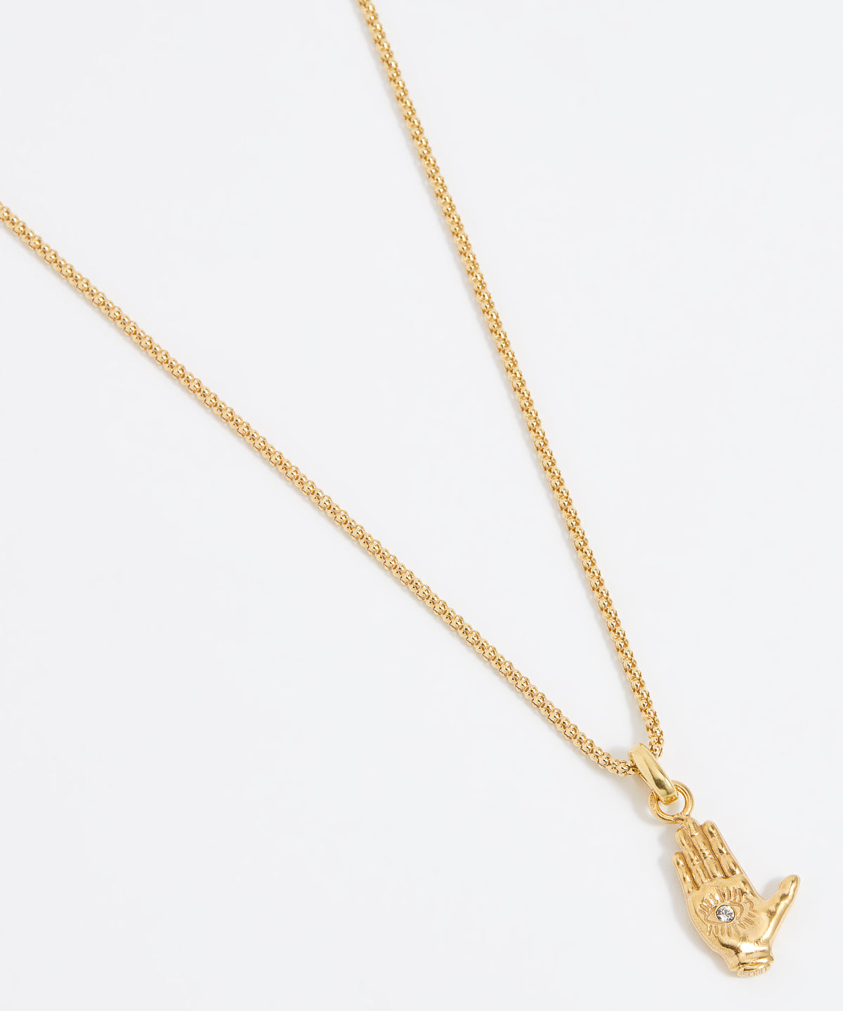 Close up shot of a gold hand-shaped charm featuring an inset eye symbol in the palm, set with a clear crystal hung from a Soru rope chain on a white background.