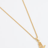 Close up shot of a gold hand-shaped charm featuring an inset eye symbol in the palm, set with a clear crystal hung from a Soru rope chain on a white background.