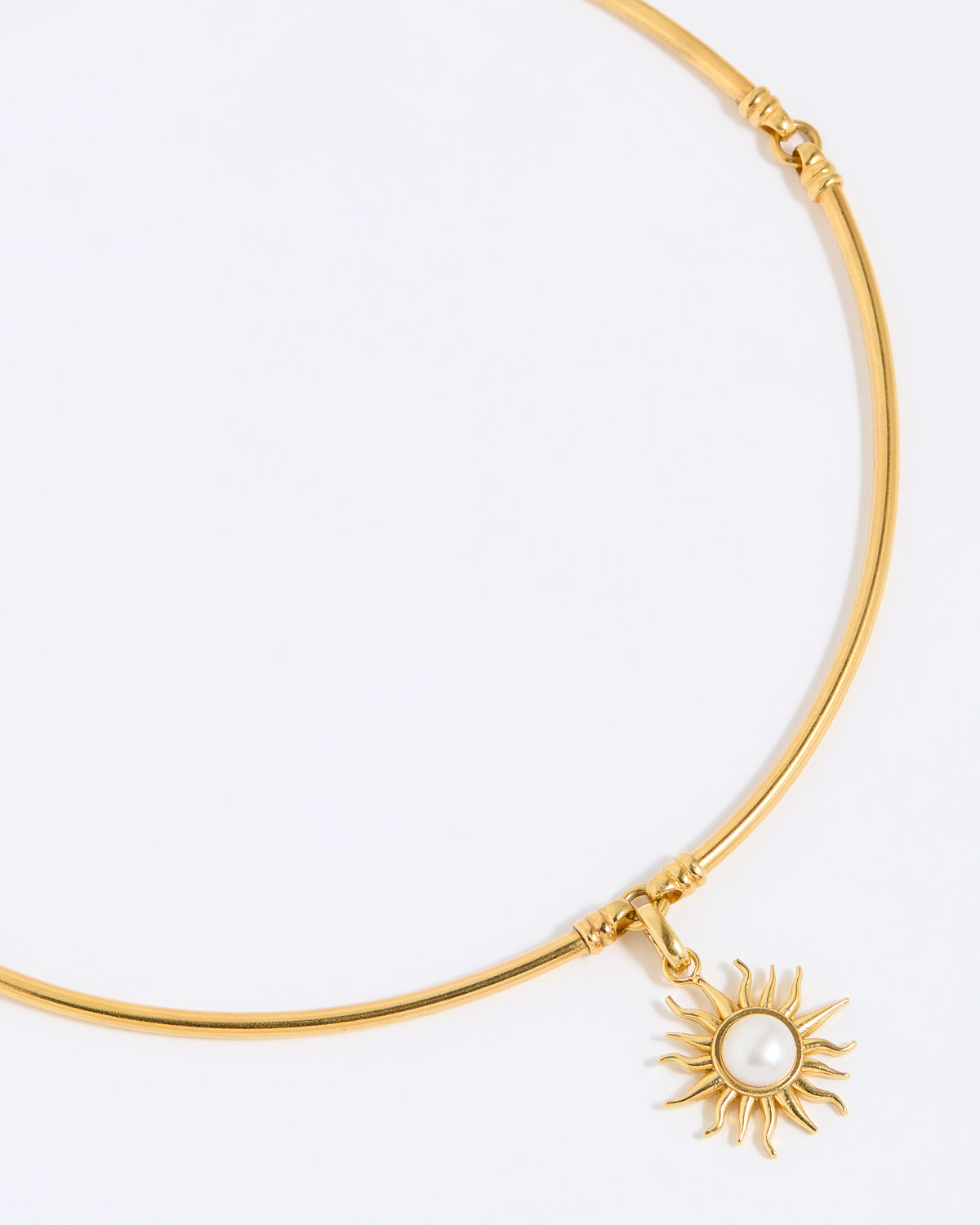 Gold choker with a sun-shaped charm on a white background