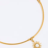 Gold choker with a sun-shaped charm on a white background