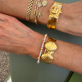 gold cuffs being worn on wrists 