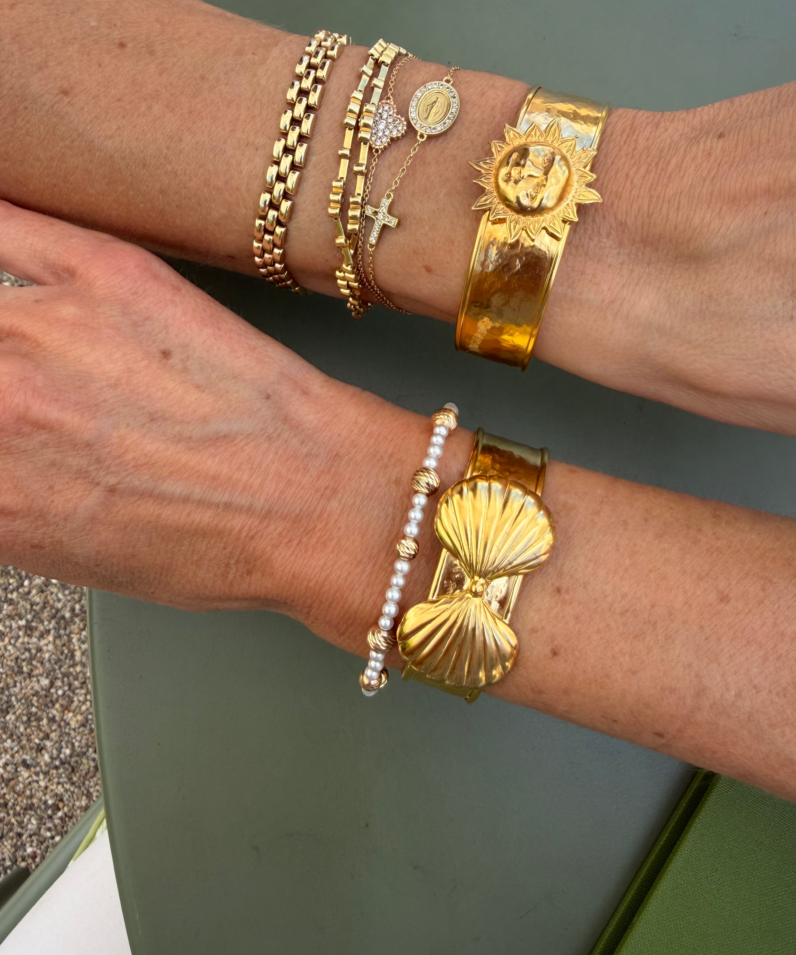 gold cuffs being worn on wrists 