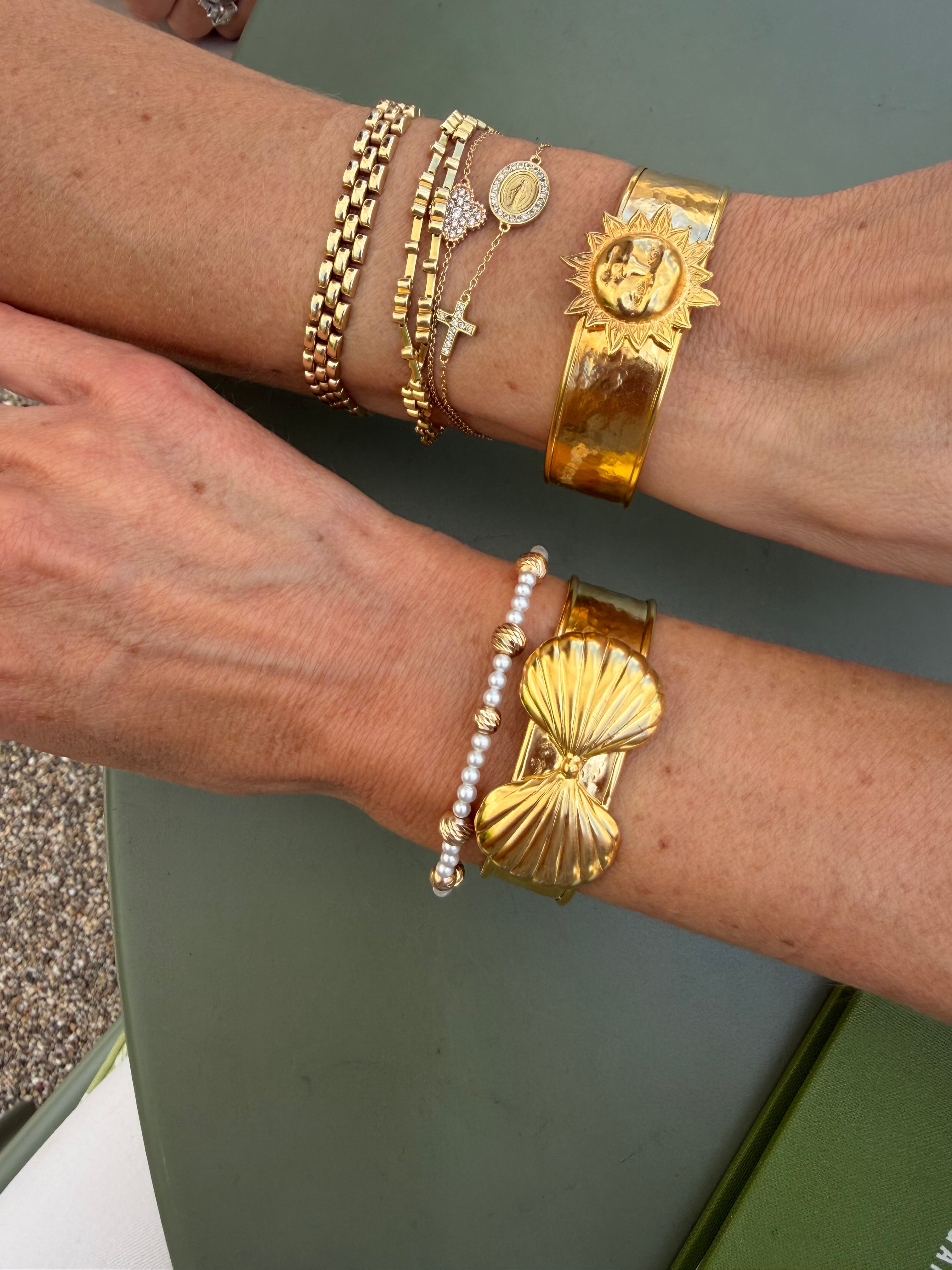 gold cuffs being worn on wrists 