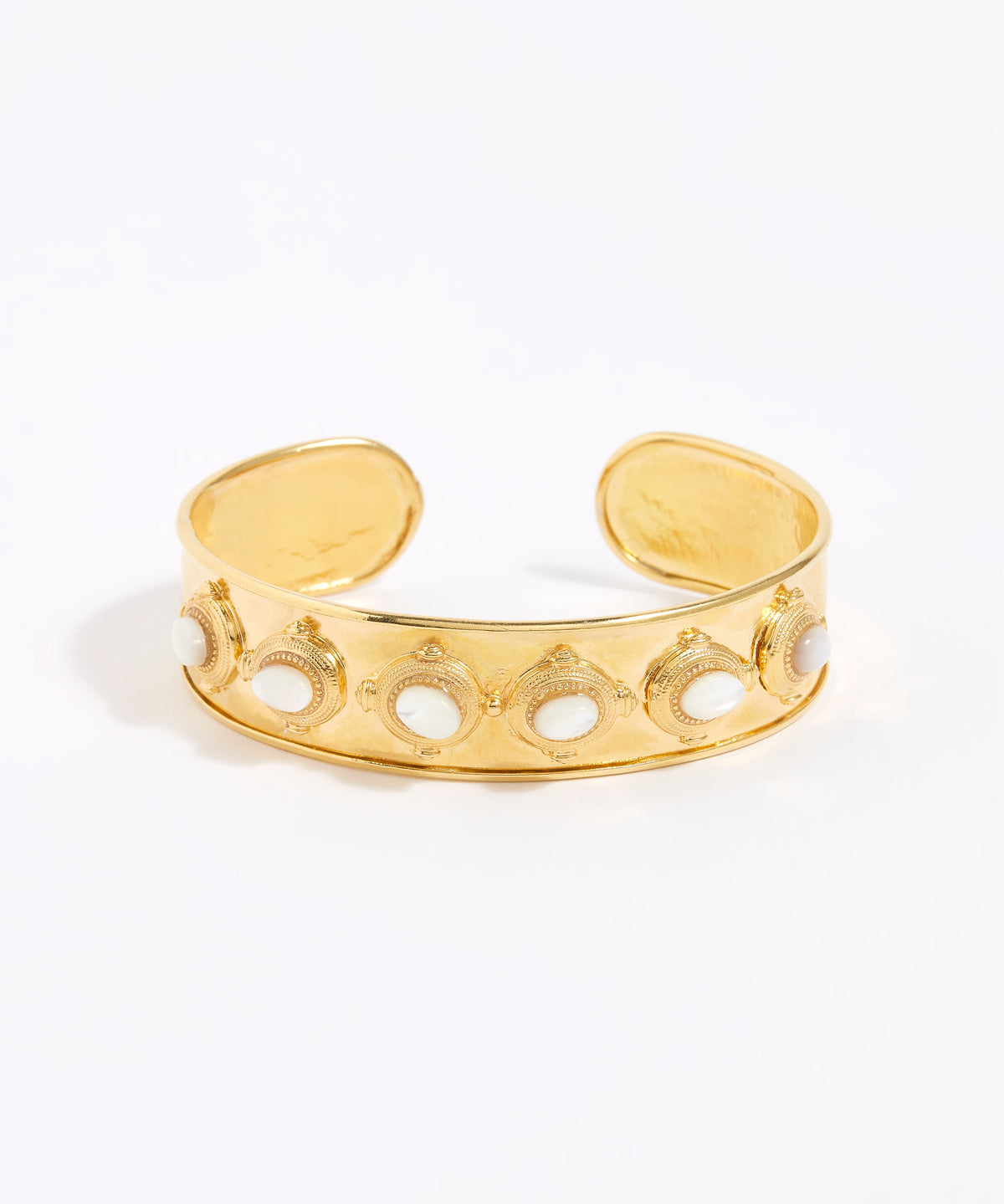 Gold cuff with intricate design and 6 small oval mother of pearls shown on a white background