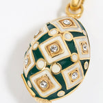 egg shaped Decorative charm pendant with green and gold design on a white background