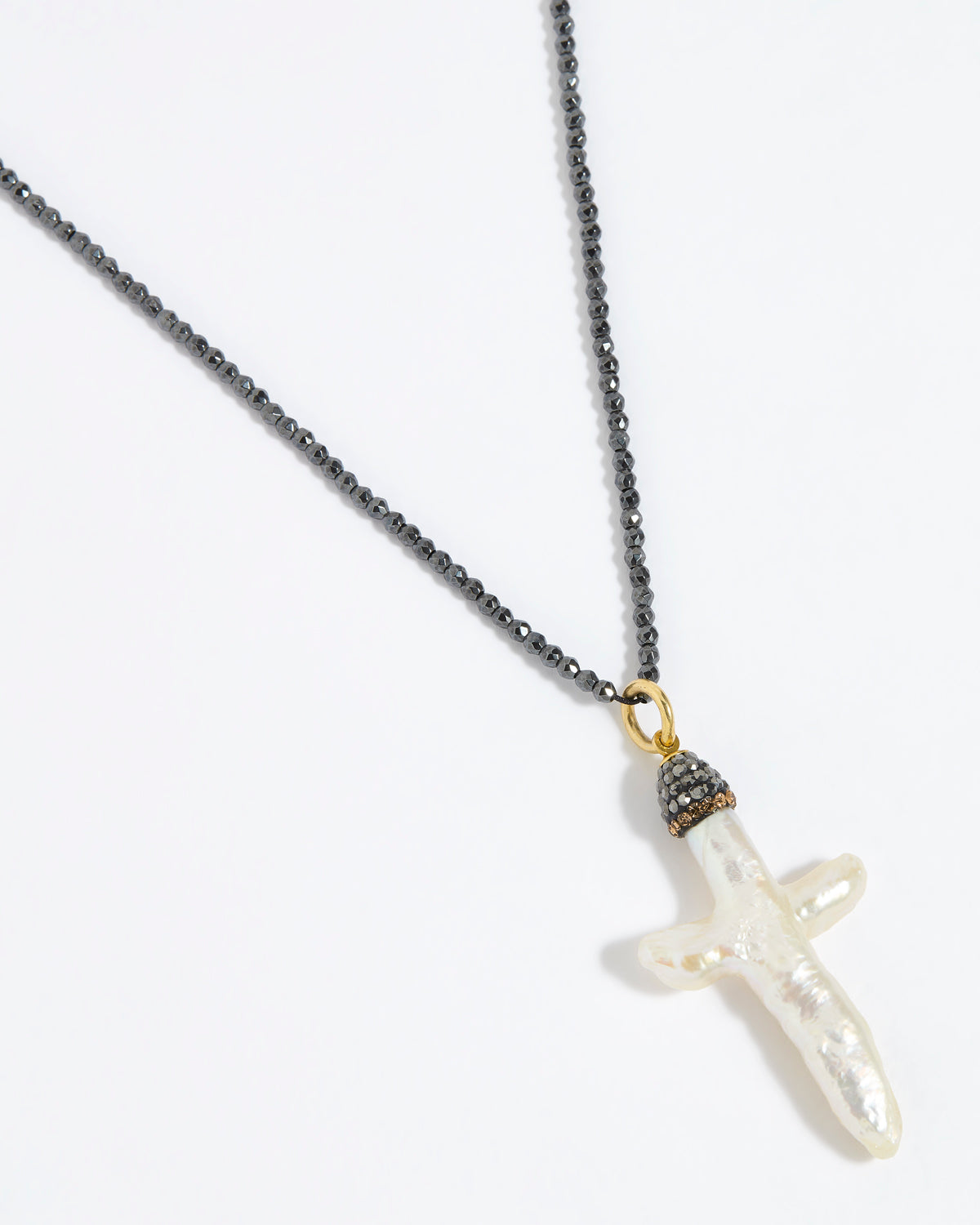 Pewter coloured beaded necklace with a white Baroque Pearl Cross pendant on a white background