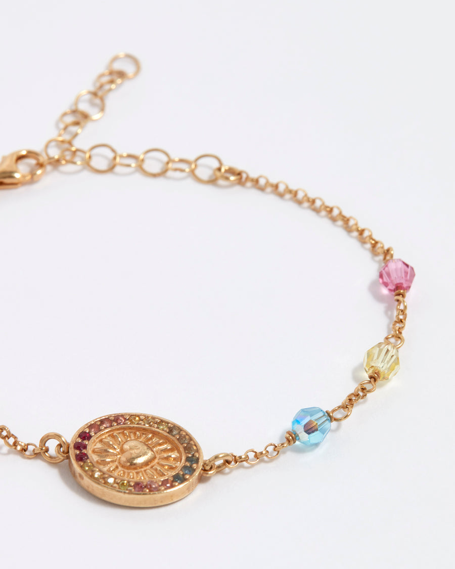 close up of pink, purple, orange, yellow and blue crystal bracelet on gold chain with love heart centre