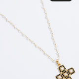 Gold necklace with a cross pendant on a white background, featuring a 'Save 15%' label.
