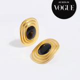 product shot of oversized gold plated silver stud earrings with oval black onyx centre