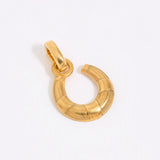 Small gold coloured horse shoe charm on white background