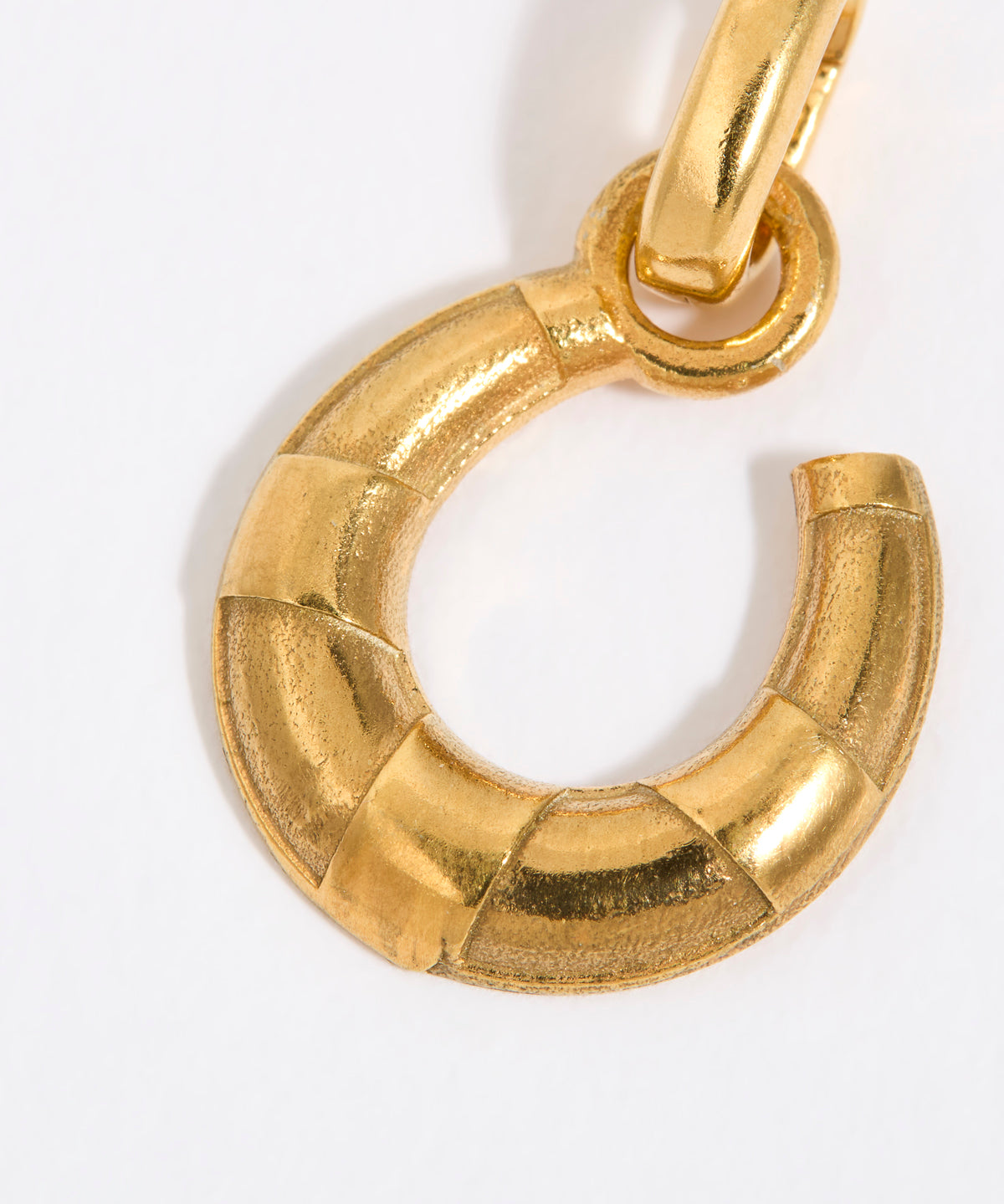 Gold coloured horse shoe pendant on a white background