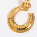 Gold coloured horse shoe pendant on a white background