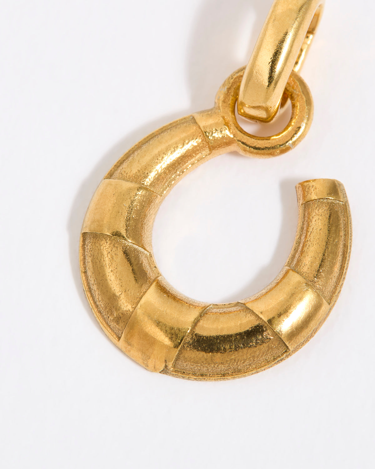 Gold coloured horse shoe pendant on a white background