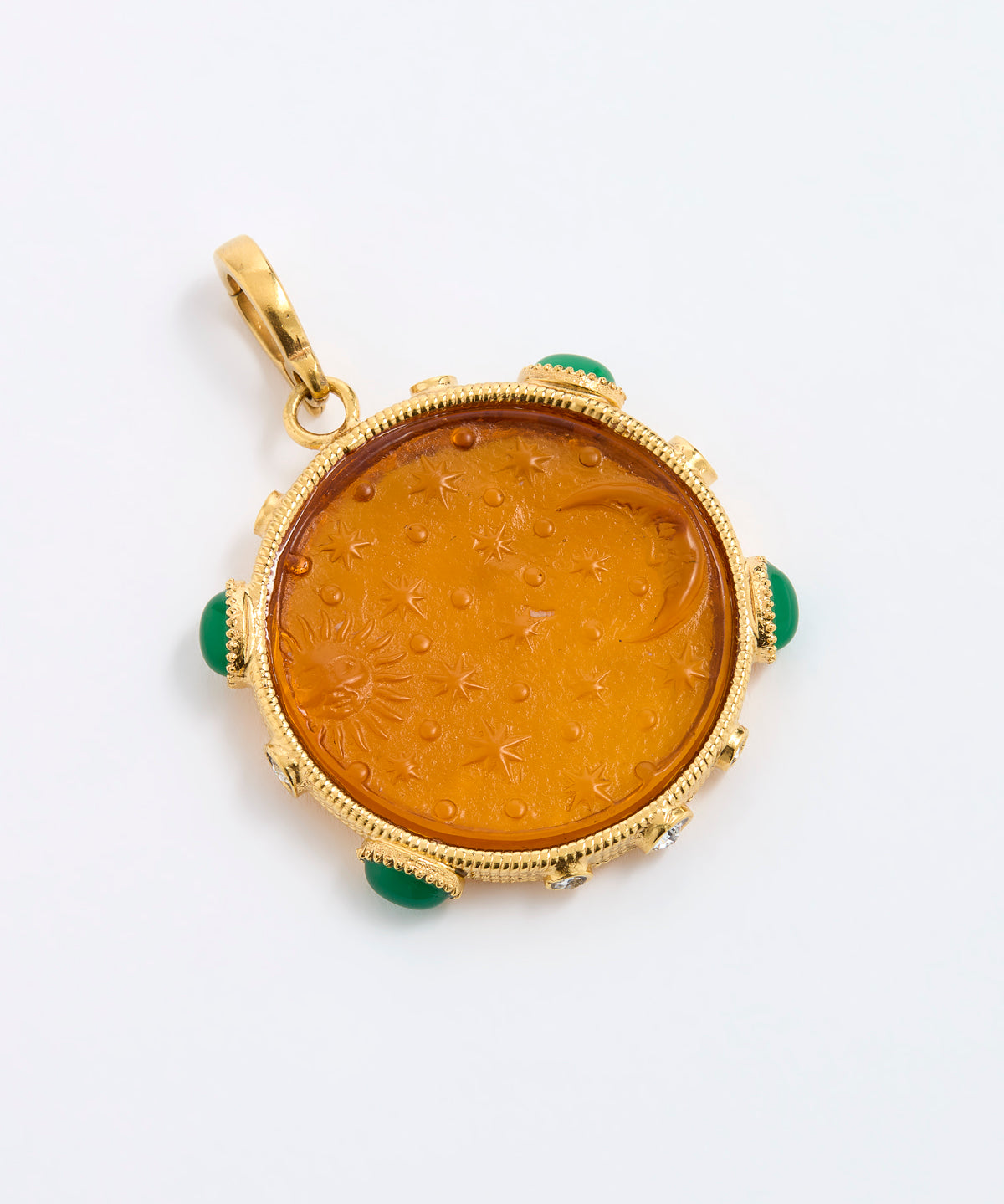 A round gold pendant featuring an amber-colored carved center with green stone accents at the corners, shown on a plain white background.