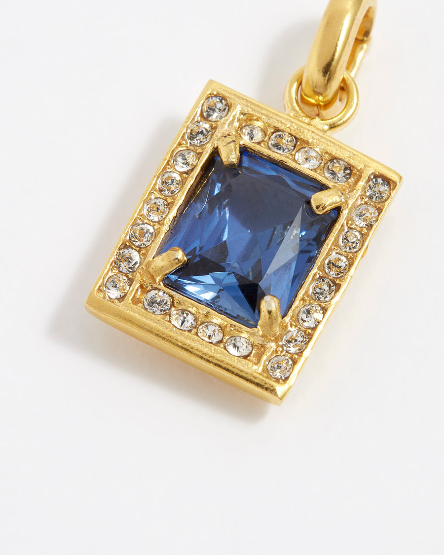 product shot of blue crystal square charm surrounded by clear crystals close up