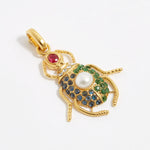 product shot of scarab beetle charm encrusted with red, bue and green crystals and one pearl on the back