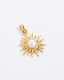 Product shot of gold textured charm in the shape of a blazing sun with centre pearl on white back ground.
