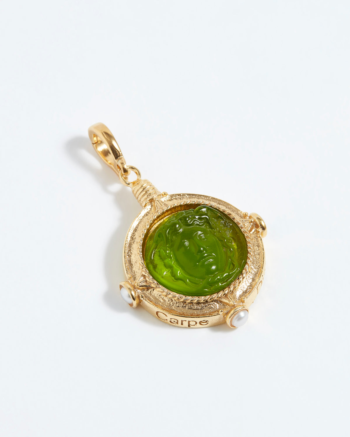 Gold pendant with green gemstone on a white background