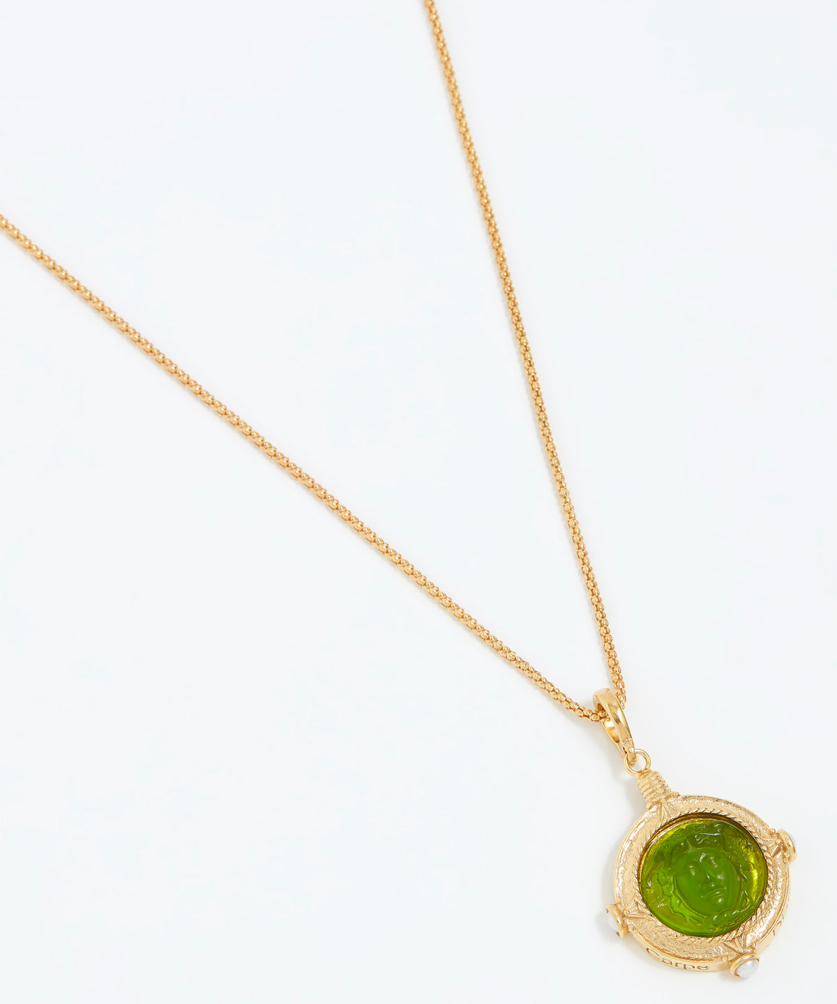 Gold necklace with a green pendant on a white background