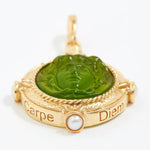 Gold pendant with green stone and pearl on a white background