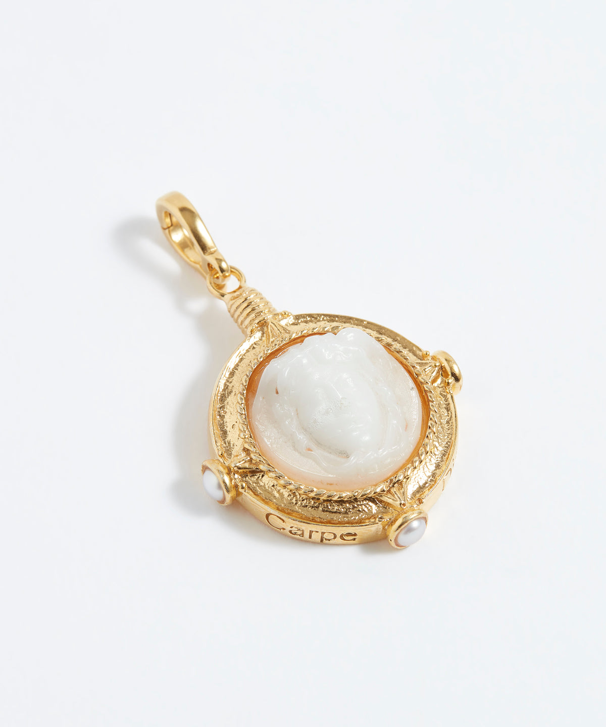 Gold pendant with a white stone on a light gray background