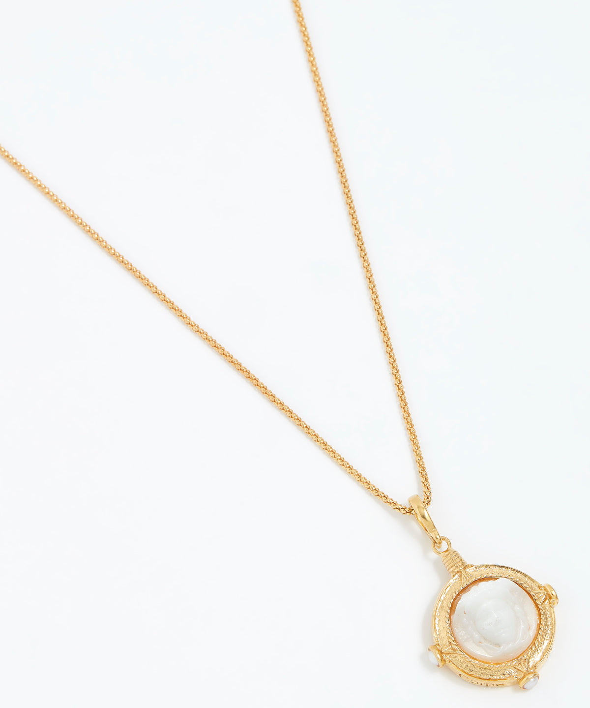 Gold necklace with a white pendant on a white background