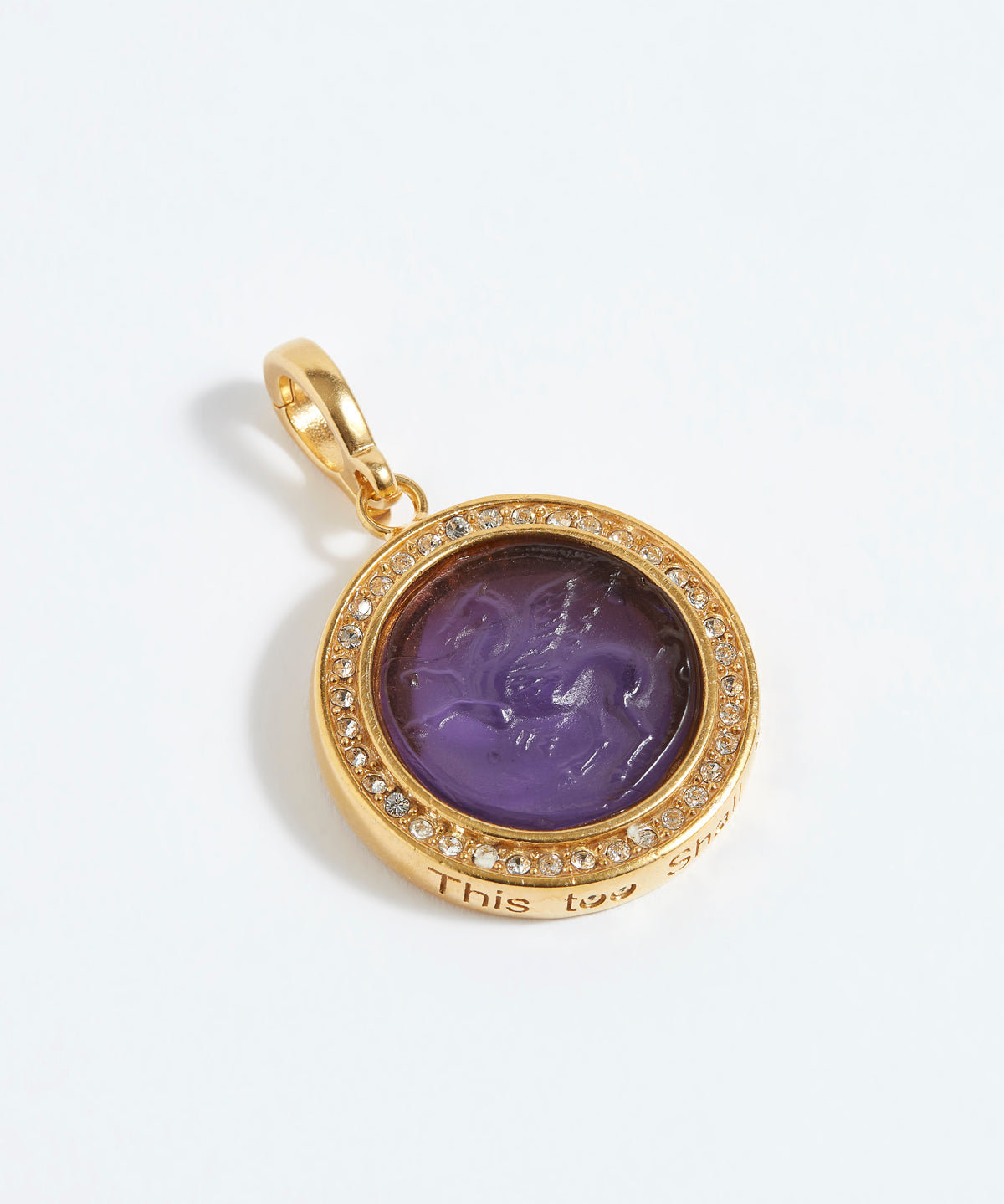 Gold pendant with purple center and diamond accents on a white background