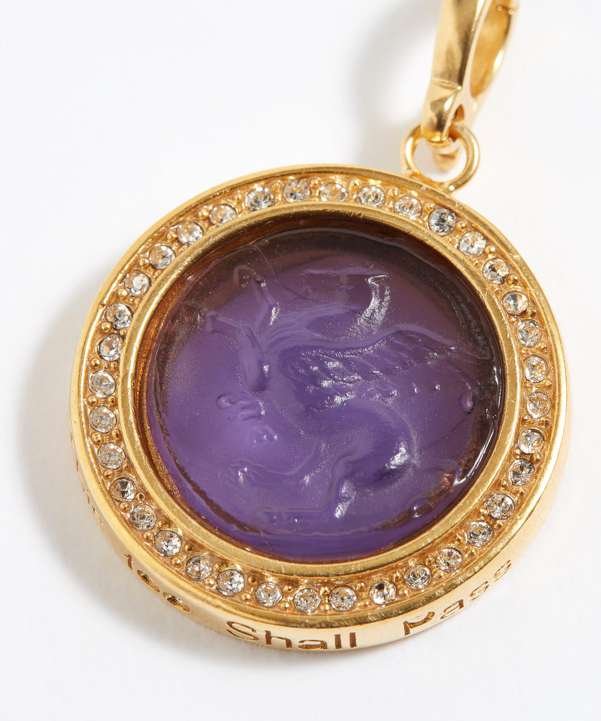 Gold pendant with purple stone and engraved design "this too shall pass" on a white background