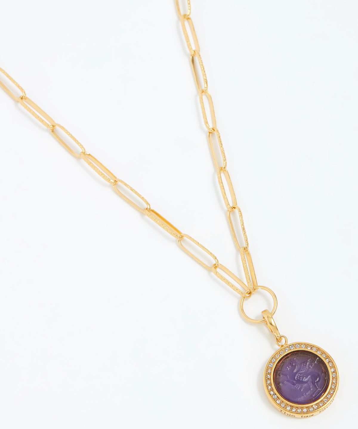 Gold necklace with a purple pendant on a white background