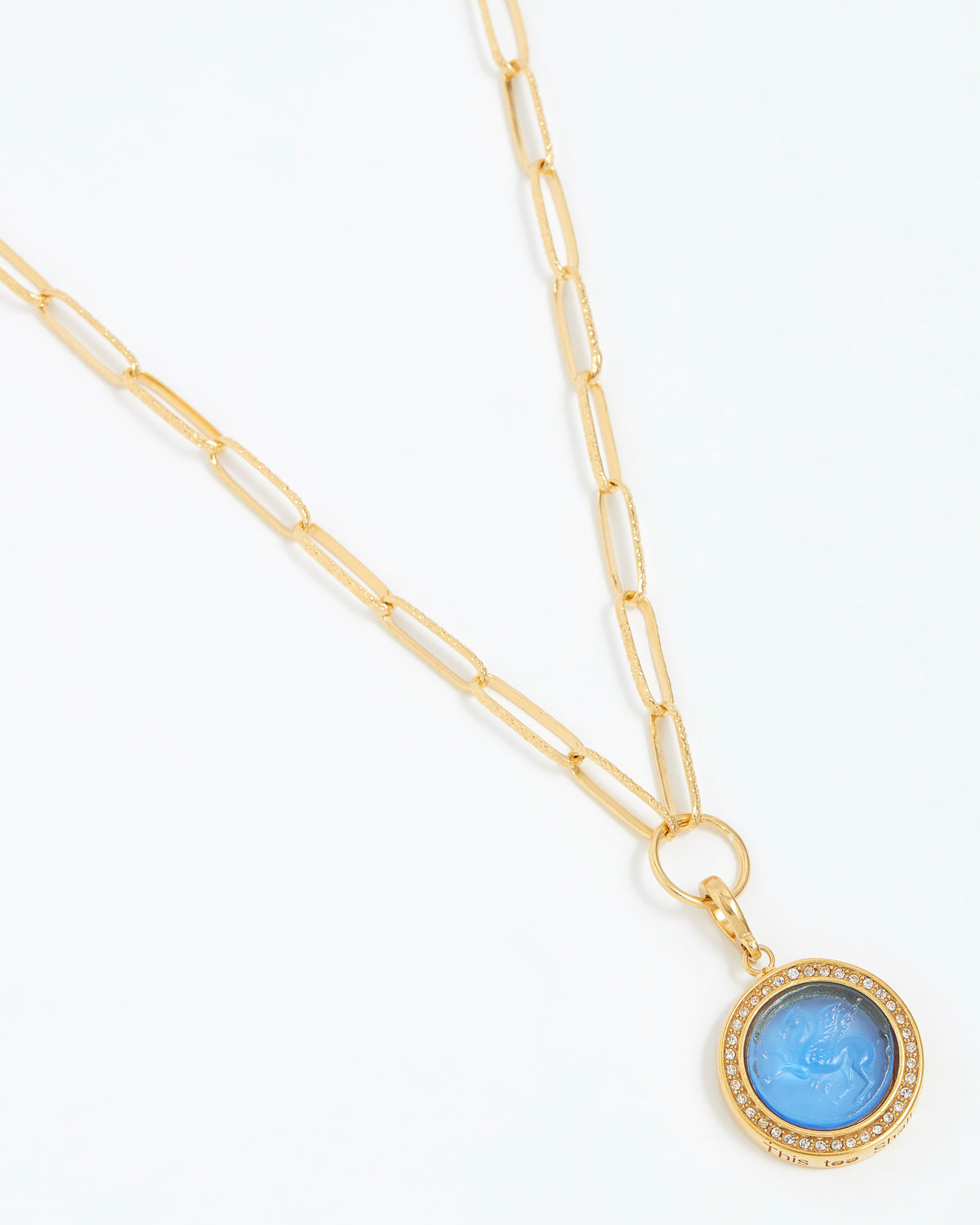 Gold chain necklace with a blue pendant on a white background