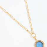 Gold chain necklace with a blue pendant on a white background