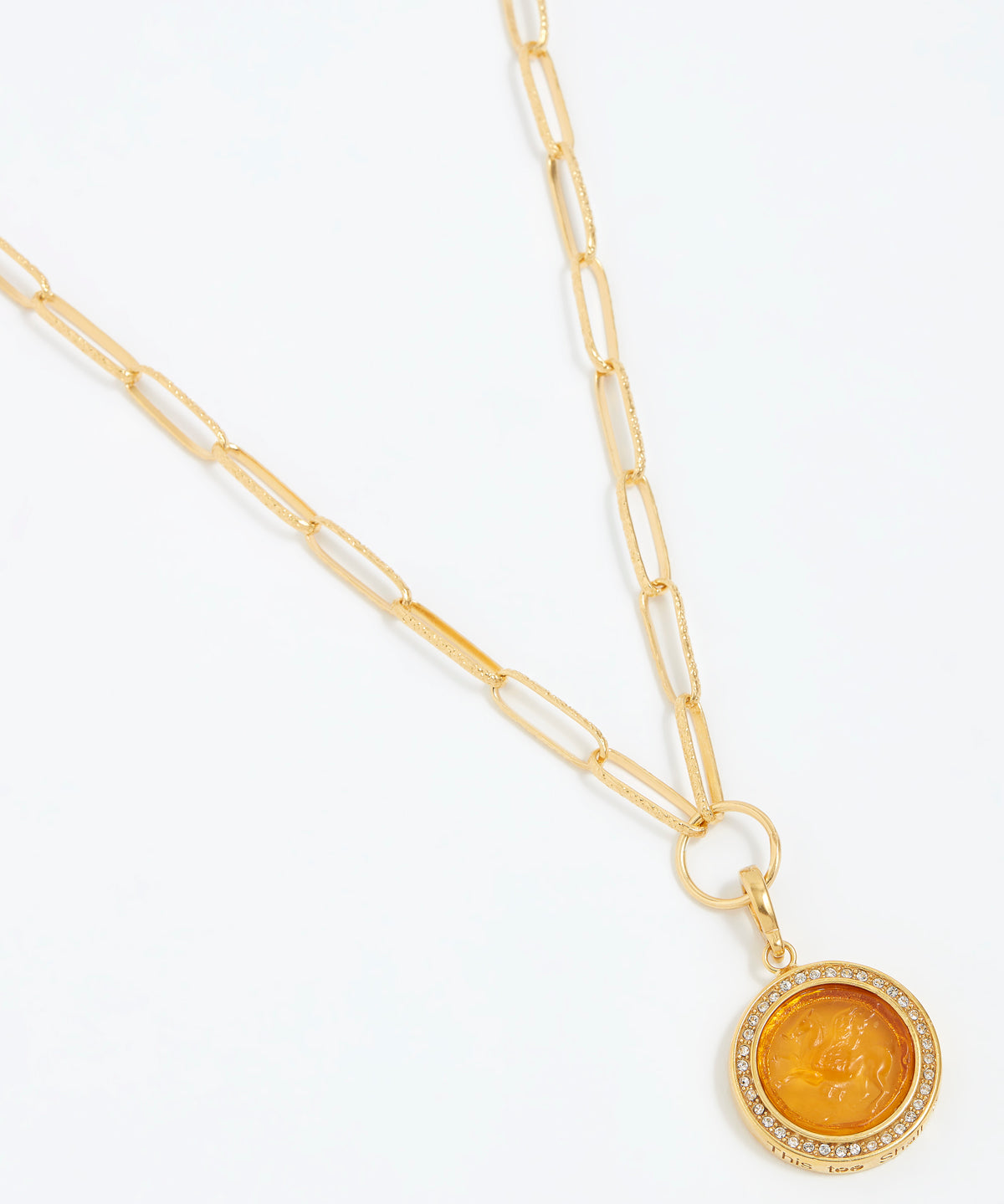 Gold necklace with a round pendant on a white background