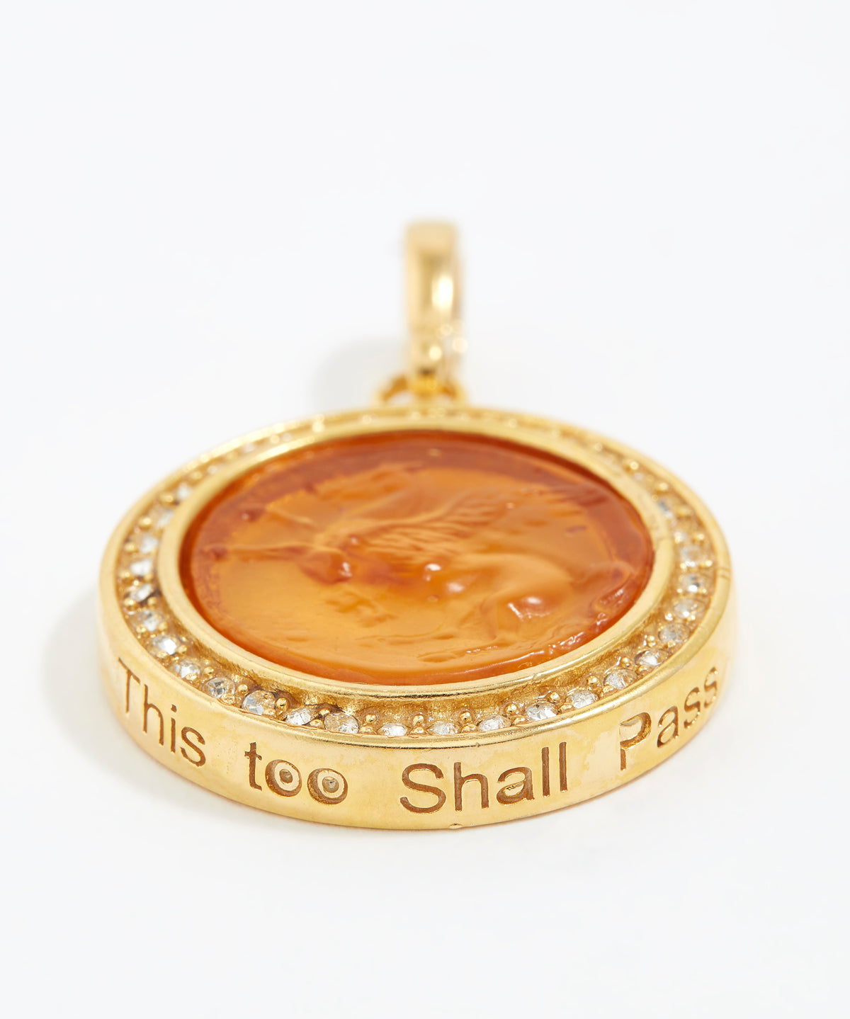 Gold pendant with engraved text "this too shall pass" on a white background